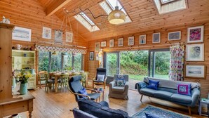 Ein gemütliches Blockhaus-Interieur mit Holzwänden, einer Essecke und einer Couch.