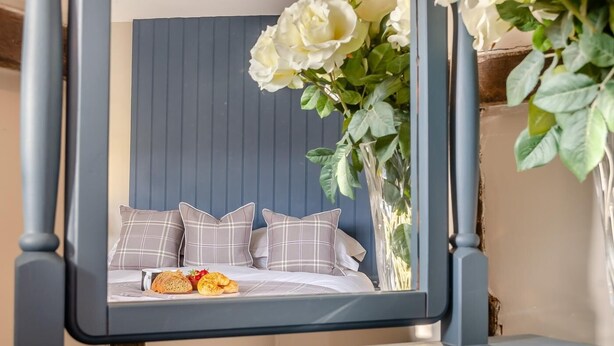 Un lit avec une tête de lit, des oreillers et un plateau de petit-déjeuner.