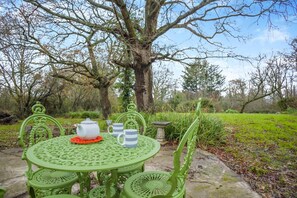 A green metal table set outdoors with a teapot, cups, and saucer. - 2 Bed in Woodchurch (oc-b30323) (Woodchurch)