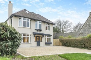 A two-story house with a front porch, a chimney, and a gravel driveway. - 5 Bed in Corfe Castle (oc-r30456) (Corfe Castle)