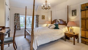 A four-poster bed with a chandelier, a wooden wardrobe, and a bedside table with a lamp. - 3 Bed in Uploders (oc-g30276) (Uploders)