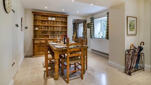A dining area with a wooden table and chairs, a wine rack, and a clock on the wall. - 3 Bed in Uploders (oc-g30276) (Uploders)