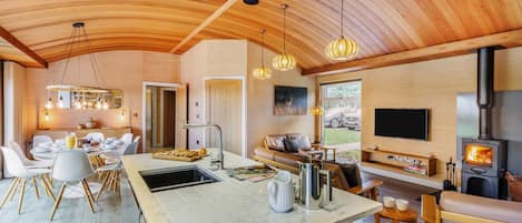A modern kitchen with a marble countertop, a built-in stove, and pendant lighting.