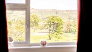 A window with a view of a rural landscape, including trees and rolling hills. - 3 Bed in Hawes (oc-s30429) (Hawes)