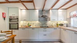 Eine moderne Küche mit weißen Schränken, Backofen, Mikrowelle und Gasherd.