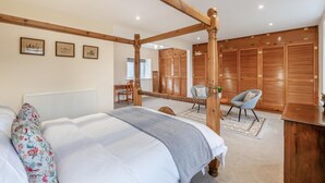 A bedroom with a four-poster bed, wooden wardrobe, and a desk with chairs. - 6 Bed in Rudston (oc-s30441) (Rudston)