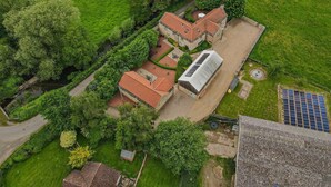 An aerial view of a property with a main building, a greenhouse, and surrounding green fields. - 3 Bed in Crakehall (oc-m30356) (Kirkbridge)
