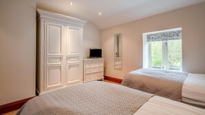A bedroom with two beds, a wardrobe, a television, a mirror, and a window with a view of greenery. - 2 Bed in Crakehall (oc-m30355) (Kirkbridge)