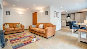 A modern living room with two sofas, a coffee table, and a kitchen area in the background. - 2 Bed in Crakehall (oc-m30355) (Kirkbridge)