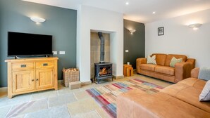 A living room with a television, wooden cabinet, sofa, and a fireplace. - 2 Bed in Crakehall (oc-m30355) (Kirkbridge)
