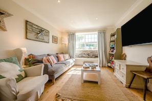 A living room with a sofa, coffee table, and a television. - 4 Bed in Trevillick (oc-m30376) (Tintagel)
