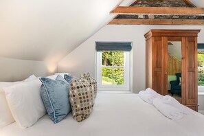 A bedroom with a bed, pillows, a window, and a wooden wardrobe. - 4 Bed in St. Brides (oc-h30490) (Saint Brides)