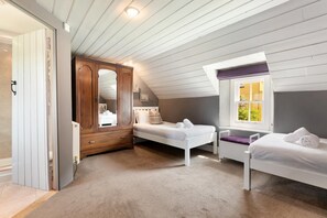 A bedroom with two beds, a wardrobe, a window, and a ceiling with exposed beams. - 2 Bed in St. Brides (oc-k30489) (Saint Brides)