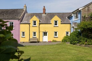 A row of colorful houses with a grassy yard in front. - 2 Bed in St. Brides (oc-k30489) (Saint Brides)