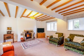 A cozy living room with a fireplace, wooden beams, a television, and patterned furniture. - 4 Bed in Mallerstang (oc-s22487) (Mallerstang)