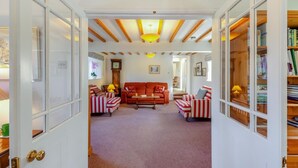 A cozy living room with striped armchairs, a red sofa, and a wooden ceiling. - 4 Bed in Mallerstang (oc-s22487) (Mallerstang)
