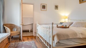 A bedroom with a bed, a chair, a nightstand, and a lamp. - 3 Bed in Brighstone (oc-r30510) (Brighstone)