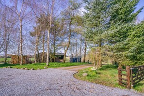 A gravel driveway leading to a rustic wooden building with a metal gate. - 1 Bed in Methven (oc-v30533) (Methven)
