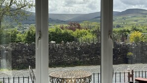 A room with a view of a rural landscape, stone walls, and a round table with chairs. - 2 Bed in Hawes (oc-b30521) (High Abbotside)