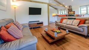 A modern living room with a sofa, coffee table, and a TV. - 3 Bed in Winnards Perch (oc-m30557) (Winnard's Perch)