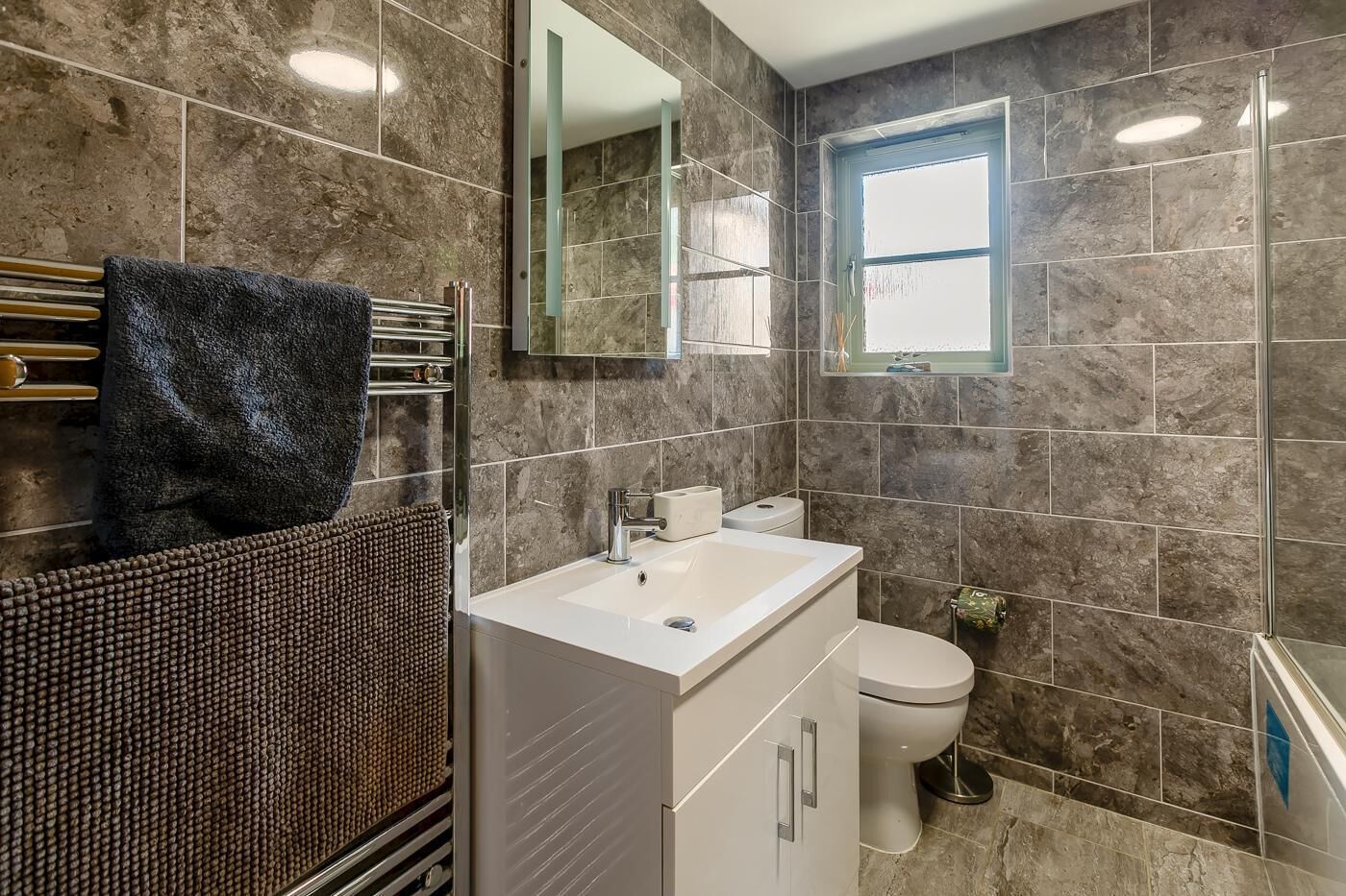 Ein Badezimmer mit Waschbecken, Toilette und Spiegel.