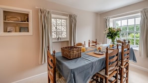 Een eetkamer met een ontbijt aan tafel, inclusief borden, glazen en een mand.