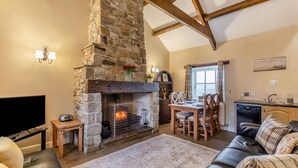 A cozy living room with a stone fireplace, a dining area, and a kitchen. - 2 Bed in Eggleston (oc-s30453) (Middleton-in-Teesdale)