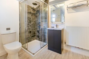 A bathroom with a glass-enclosed shower, a toilet, a sink with a mirror, and a radiator. - 2 Bed in Sennen (oc-t30543) (Sennen)