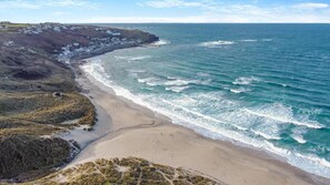 A coastal landscape with a sandy beach, rocky cliffs, and a view of the ocean. - 2 Bed in Sennen (oc-t30543) (Sennen)