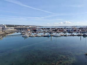 A marina with boats docked, a pier, and a distant shoreline. - 2 Bed in Newlyn (oc-t30565) (Newlyn)