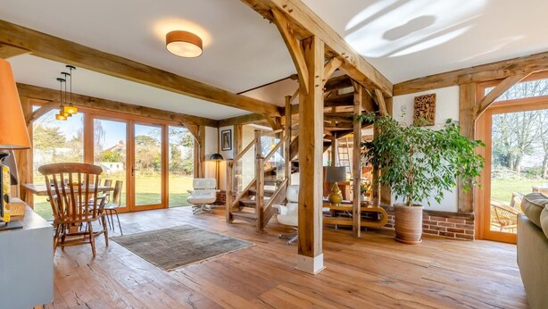 A spacious room with wooden beams, a staircase, and large windows. - 3 Bed in Mundesley (oc-o30555) (Mundesley)