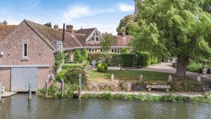 A riverside property with a brick building, a garden, and a tree. - 4 Bed in Wareham (oc-r30563) (Wareham)
