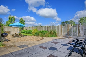 A patio with a barbecue grill, picnic table, and outdoor seating. - 3 Bed in Burton Bradstock (oc-c30570) (Burton Bradstock)