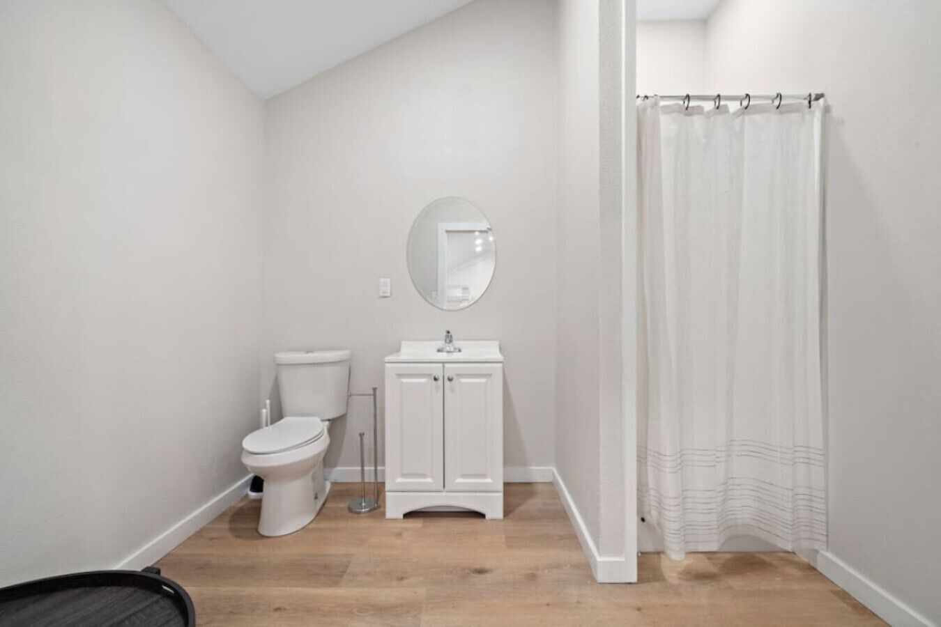 A small, clean bathroom with a toilet, sink, and shower curtain.