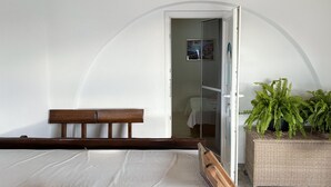 A bedroom with a wooden bed, a white wall, and a large potted fern. - 1 bedroom stunning apartment in Klek (Klek)