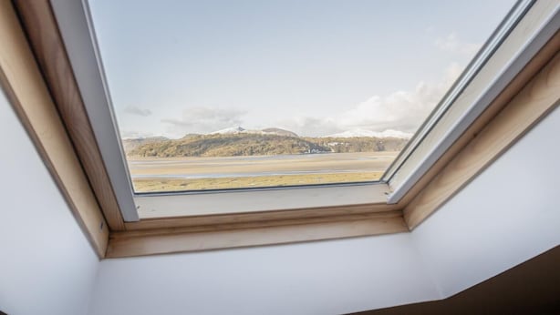 A skylight with a view of a snowy mountain and a flat landscape. - 8 Bed in Ynys (oc-c29818) (Ynys)