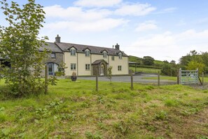 A two-story house with a stone facade and a traditional pitched roof.