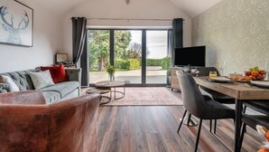Ein modernes Wohnzimmer mit Sofa, Couchtisch und Essbereich.
