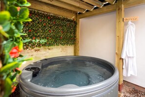 A hot tub with a wooden ceiling and a wall covered in greenery. - 4 Bed in Wellesbourne (oc-t30595) (Wellesbourne)