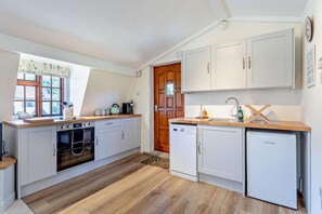 Un four, lave-vaisselle, chaise haute, vaisselle et ustensiles