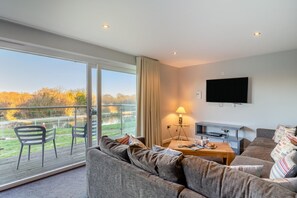 A modern living room with a sofa, a coffee table, and a TV mounted on the wall. - 6 Bed in Winnards Perch (oc-c30624) (Winnard's Perch)