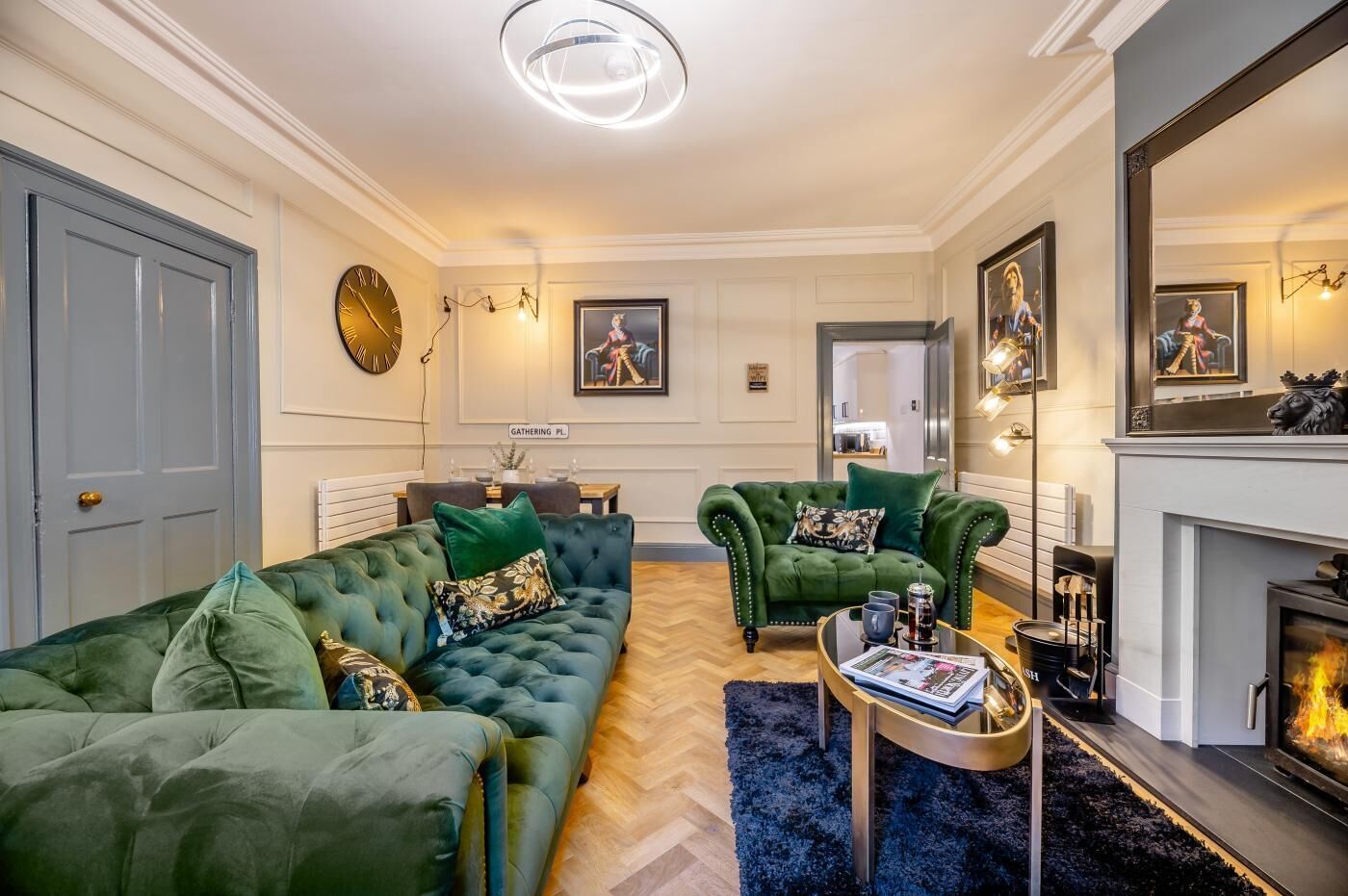 Een woonkamer met een groene bank, een salontafel en een open haard.