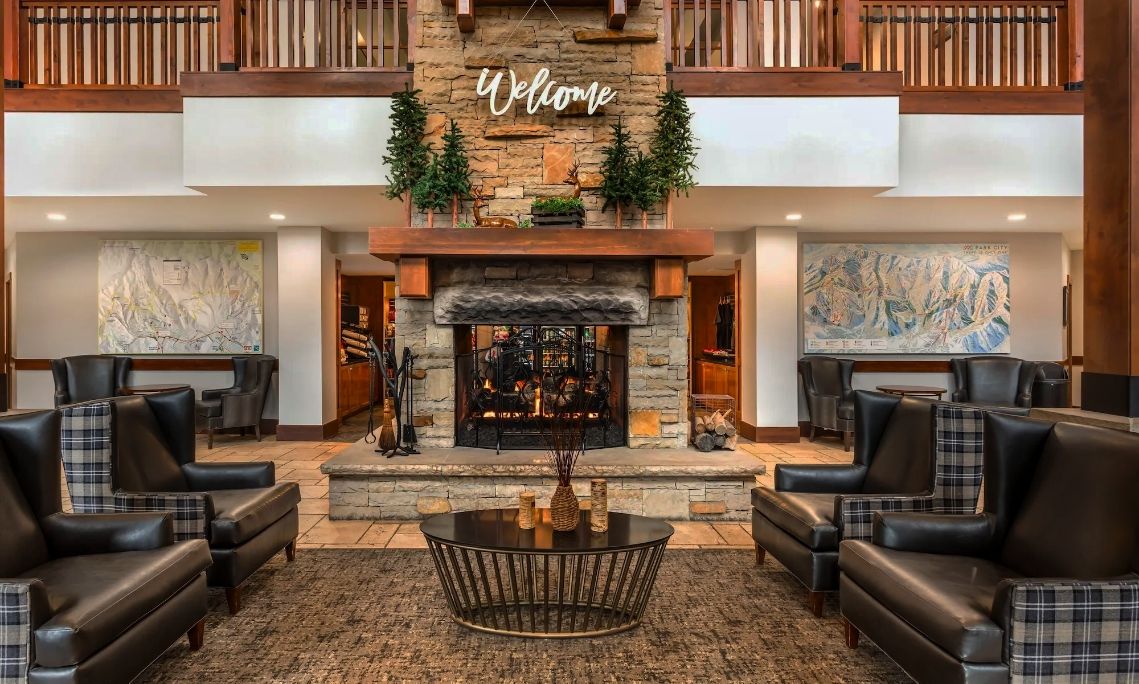A lobby with a fireplace, two large paintings, and a 'Welcome' sign above it.