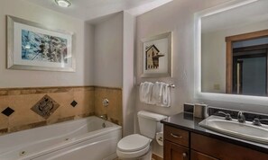 A bathroom with a bathtub, toilet, sink, and framed artwork on the walls. - Ski Park City, TG wk Nov2026, in luxury 2bdr,2 ba condo, ski-in, ski-out. (Park City)