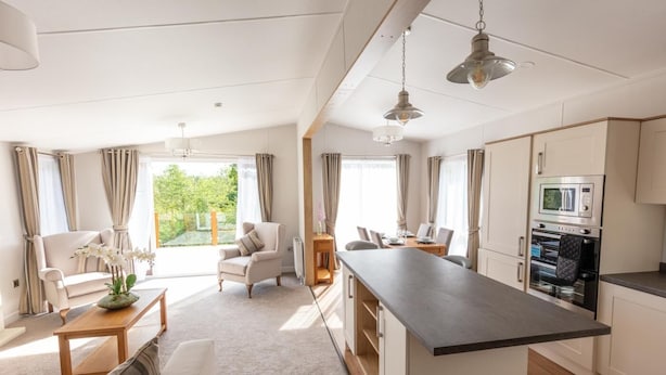 A modern kitchen with a central island, a dining area with a table and chairs, and a living room with a sofa and a coffee table. - 2 Bed in Swarland (oc-c30636) (Swarland)