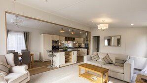 A modern living room with a sofa, coffee table, and dining area. - 2 Bed in Swarland (oc-c30636) (Swarland)