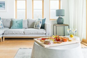 A living room with a sofa, a coffee table with food and drinks, and a lamp. - 3 Bed in St. Eval (oc-k30666) (Saint Eval)
