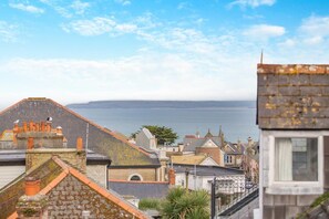 A coastal town with buildings overlooking the sea, featuring a mix of traditional and modern architecture.