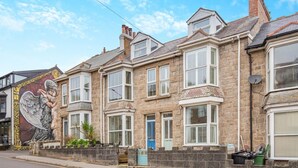 A row of stone houses with bay windows and a mural of an angel on the left. - 3 Bed in St. Ives (oc-s30653) (Saint Ive)