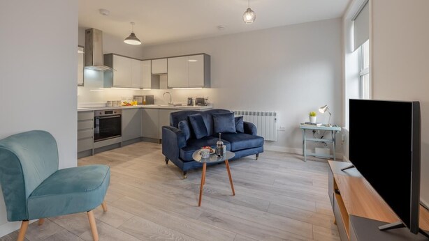 Un appartement moderne comprenant un salon, une cuisine et un coin repas.